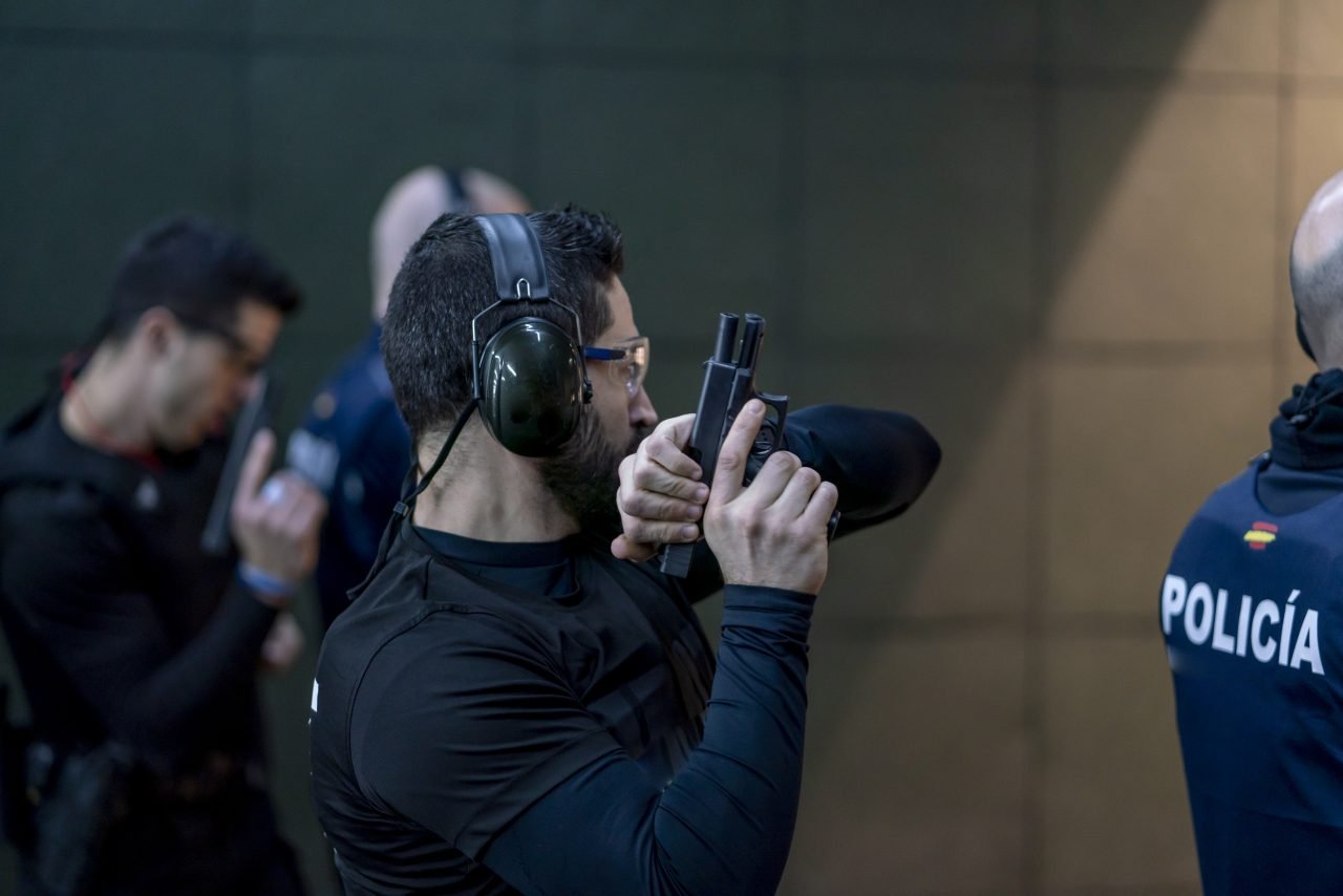 Police training in shooting gallery with short weapon.