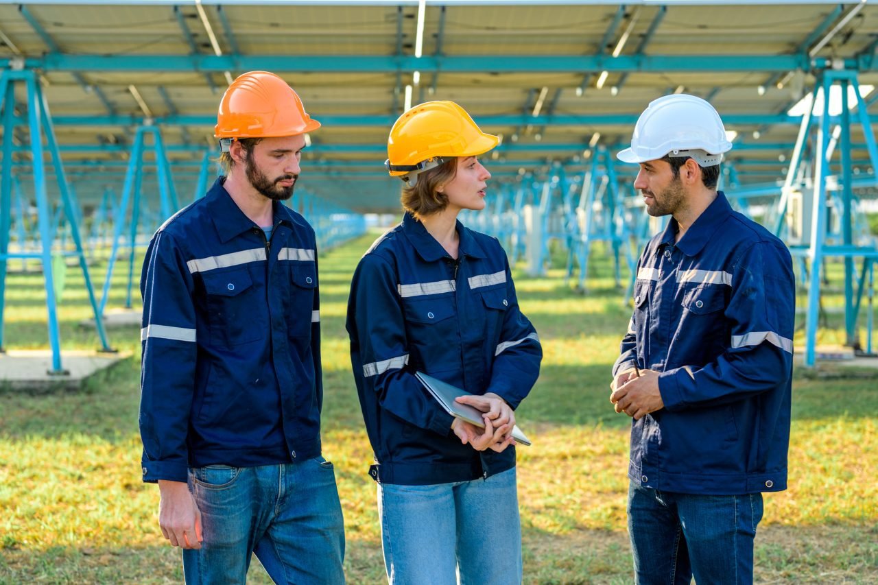 Workers installing solar panels, Engineer team at solar panel farm