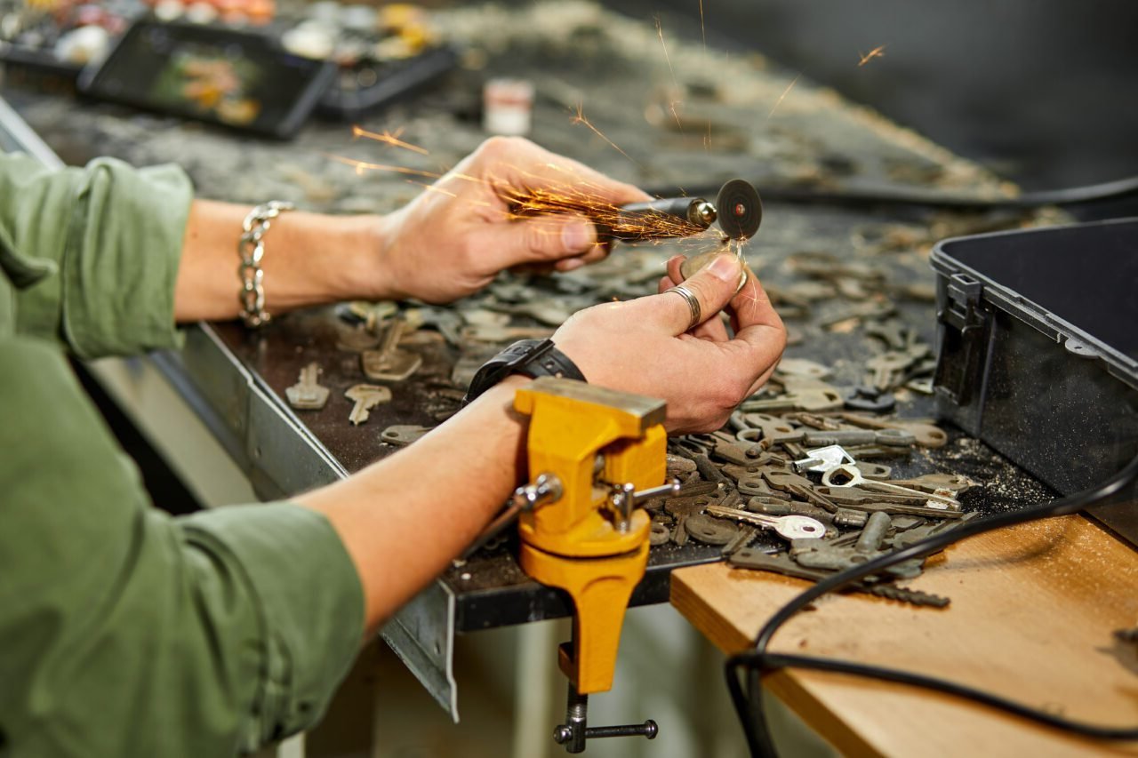 Locksmith in workshop makes new key, use grinding engraving machine